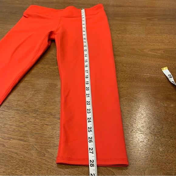 Fabletics Midrise Capris in orange with crossover waistband and hidden pocket - Picture 6 of 8